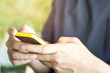 Close up of a young man using mobile smart phone focus on his hand with mining light
