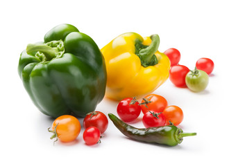 first crop of fresh vegetables bell peppers, cherry tomatoes and chili close-up isolated on white background 
