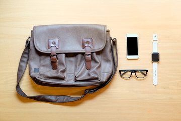 Outfit of traveler, student, teenager, young man.  Different objects on wooden background: leather...