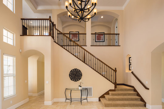 Grant Interior with staircase in large private home with granite floor and large chandelier.