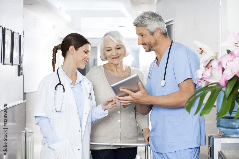 Wall mural physiotherapist showing reports to patient and doctor on tablet