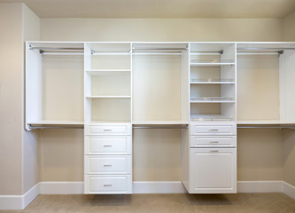 Fototapeta na wymiar Large white walk-in closet with shelves.
