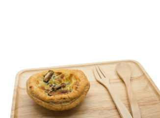 Mushroom-spinach quiche on wooden plate with spoon and fork