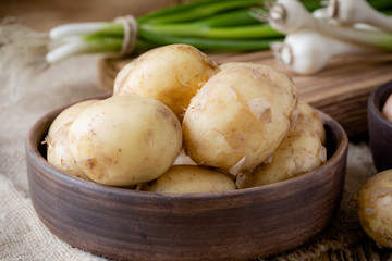 Raw organic potatoes and spring green onion, garlic. Yellow