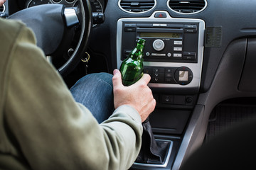 Man drinking alcohol in the car.