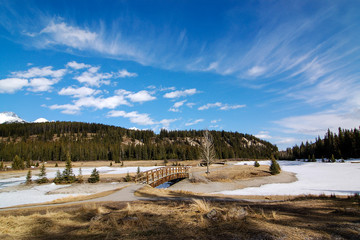 Wooden bridge and frozen Minnewanka Lake of Banff National Park