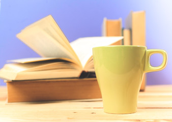 Color cup of tea with books on table
