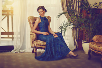 Elegant young woman in evening dress posing in luxury interior. Fashion shot