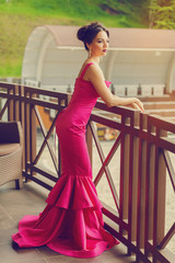 Elegant young woman in evening dress posing in luxury interior. Fashion shot