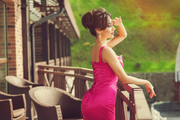 Elegant young woman in evening dress posing in luxury interior. Fashion shot