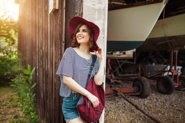 Funny Hipster Girl in old boat garage in island, Lots of boats.Trendy Casual Fashion Outfit in summer,spring. Toned Photo.