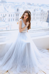 Fototapeta na wymiar Bride in a tender light blue wedding dress in a morning. Fashion beauty portrait