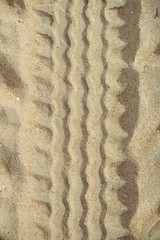 Closeup on beach sand tires print background outdoors texture