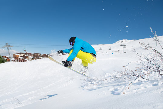 Young man jumping with snowboard