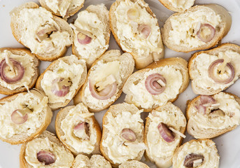 Tasty canapes with butter and onion, appetizer theme
