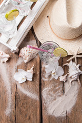 Cold water drink with ice and a slice of lime on wooden background