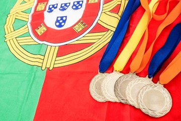 Close-up of gold medals on portuguese flag