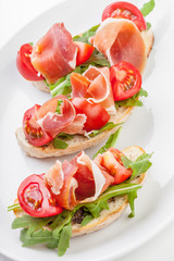 Jamon. Slices of Bread with Spanish Serrano Ham Served as Tapas. Cured ham, spanish appetizer. Prosciutto isolated on white background