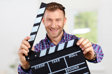 Casual man holding an open movie clap