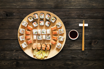 Set of sushi maki and rolls at wood background