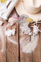 Cold water drink with ice and a slice of lime on wooden background