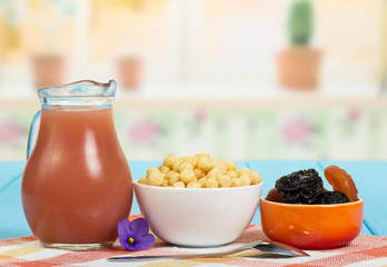 Jug with juice, dried fruit, corn balls on  background  kitchen.