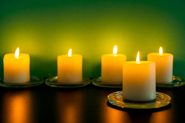 Colorful scented candles on a dark green background