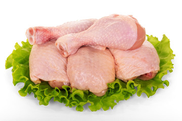Raw chicken legs and lettuce isolated on white.