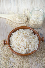 Cooked steamed rice in a blue bowl over wooden background