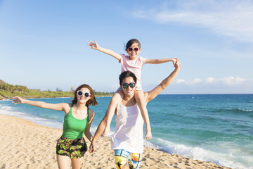 happy young family walking on the beach