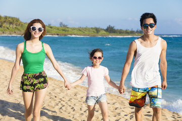 happy young family walking on the beach