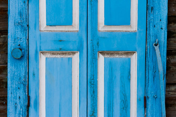 old wooden window shutters with peeling off paint and rusty
