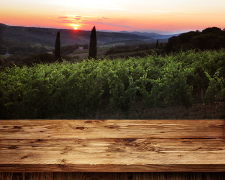 Rustic wooden table in front of a vineyard
