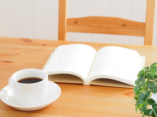テーブルの上に置かれたコーヒーと本