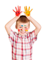 Cheerful boy with paint on his face and hands isolated.