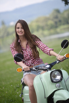 Junge Frau posiert auf einem Roller