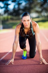Portrait of female athlete in ready to run position