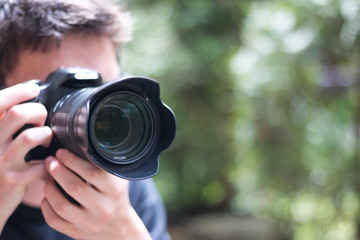 Junger Mann fotografiert mit Spiegelreflexkamera 