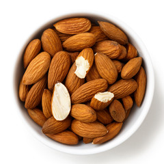Bowl of whole and broken almonds isolated on white from above.