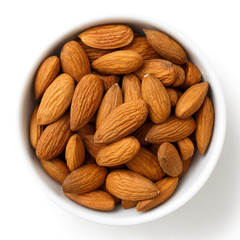 Bowl of whole almonds isolated on white from above.