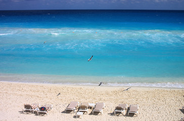 Blue sea and sunbeds. Caribbean beach in Cancun, Mexico.