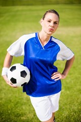 Obraz premium Female football player standing with a ball 