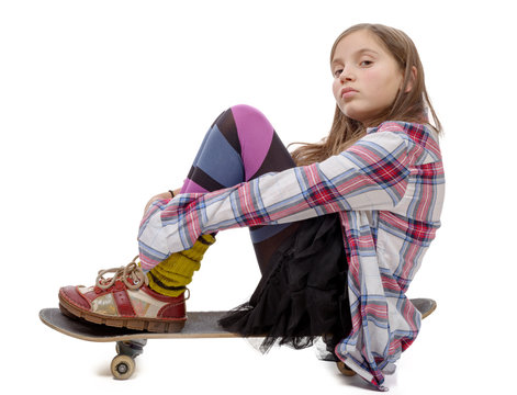 pretty young girl sitting on skate, on white