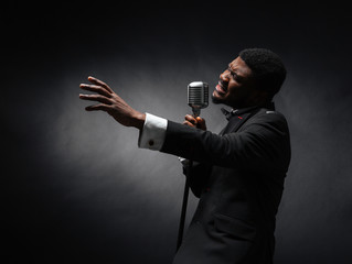 Afro amerian man singing into vintage microphone