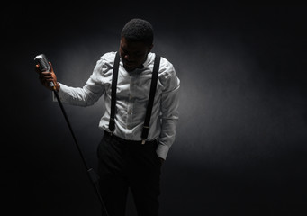 Male singer posing over dark background