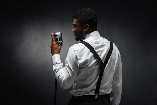 Afro american man singing into vintage microphone