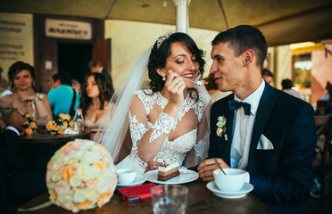 Bride and groom drinking coffee at an outdoor cafe