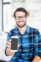 Cute hipster with glasses showing smartphone screen