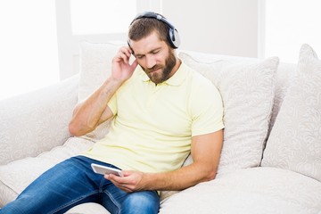 Thoughtful man listening to music on headphones