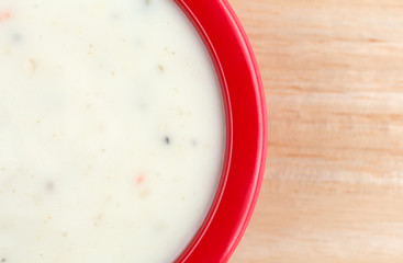 Top close view of a small bowl of Italian salad dressing on wood table